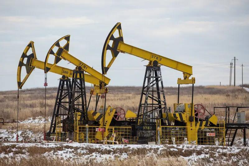 Oil ticks higher, head for annual loss